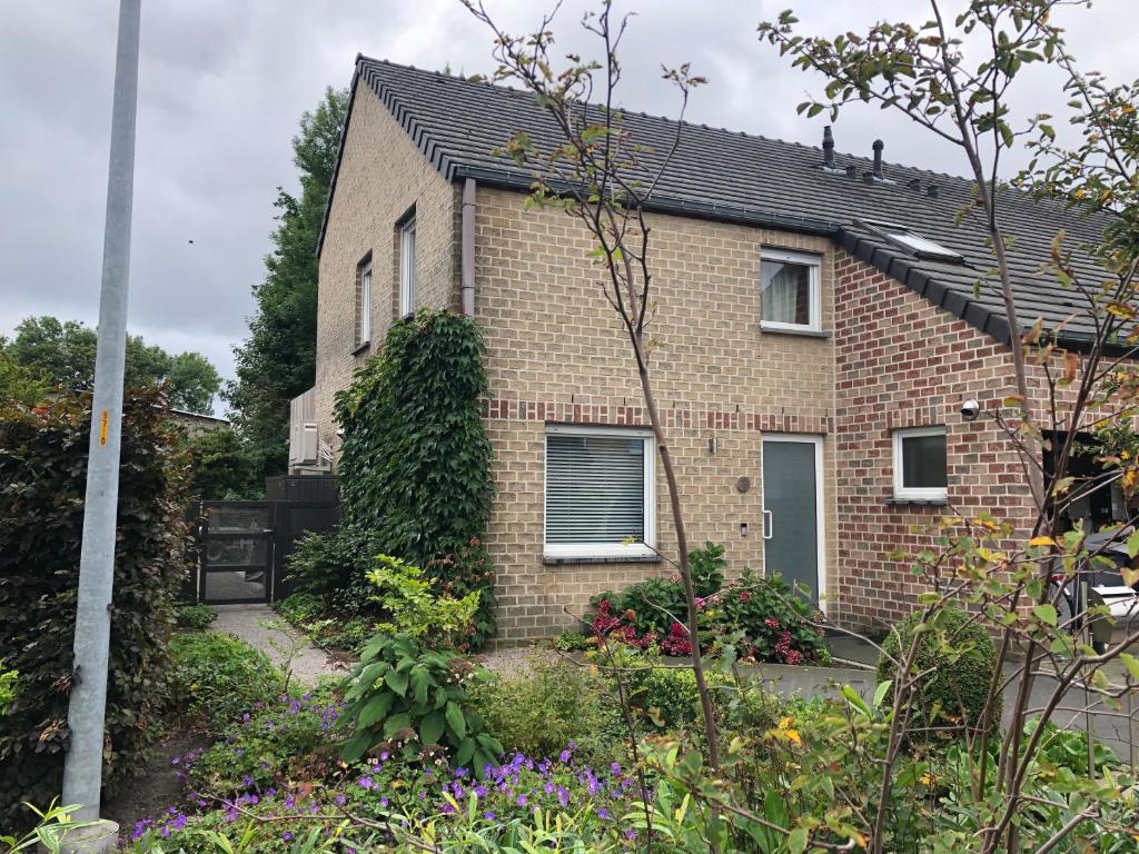 a brick house with a garden in front of it at Het Nekkerhof B&Bio in Mechelen