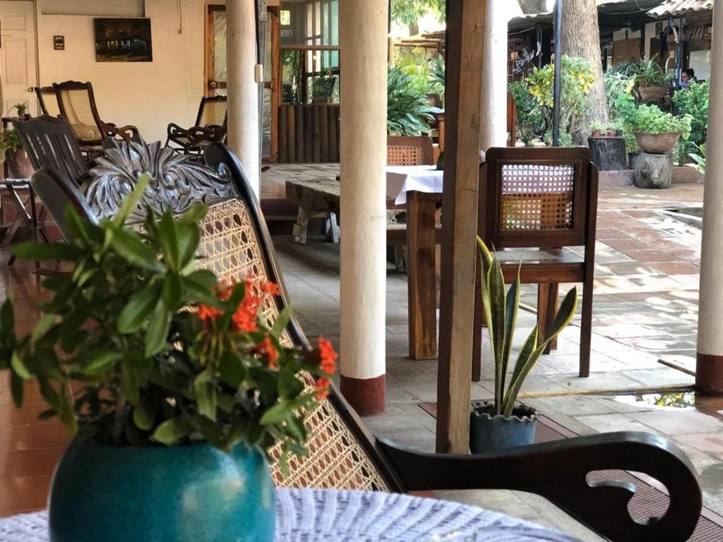 un patio con sillas y una mesa con macetas. en Casa de Los Berrios en León