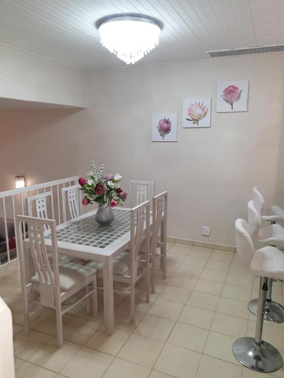 a dining room with a table and chairs and flowers at Villa 2527 San Lameer in Southbroom