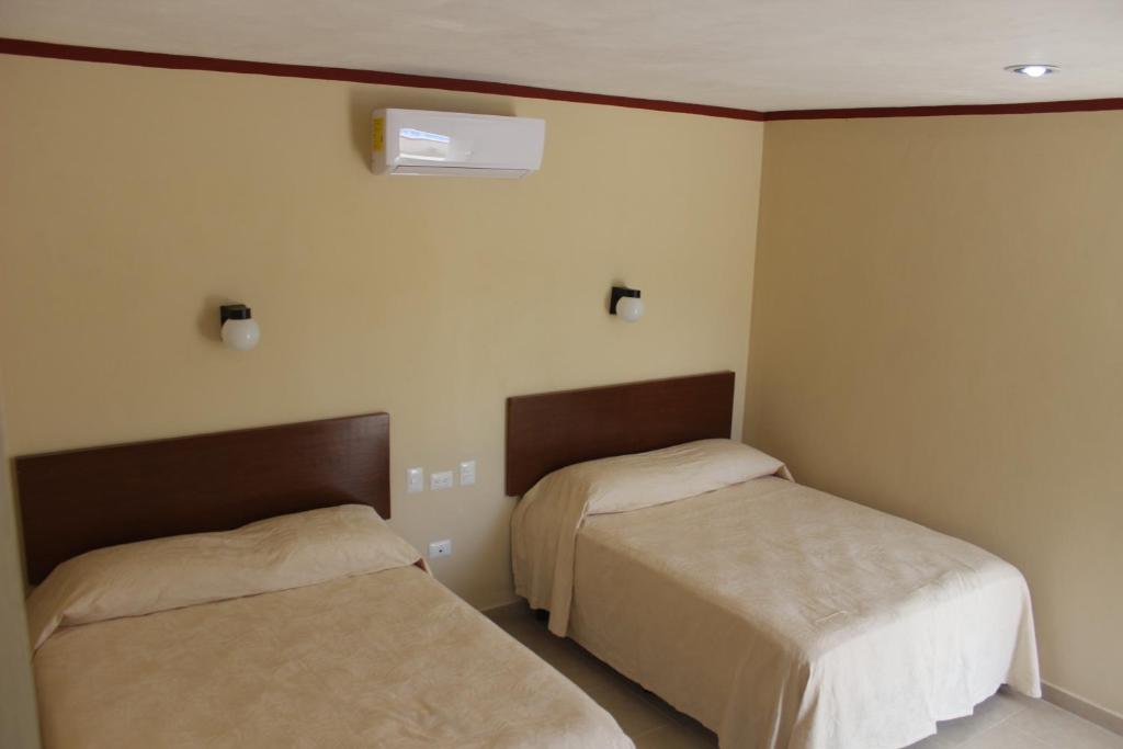 Postel nebo postele na pokoji v ubytování Hotel La Piramide Izamal