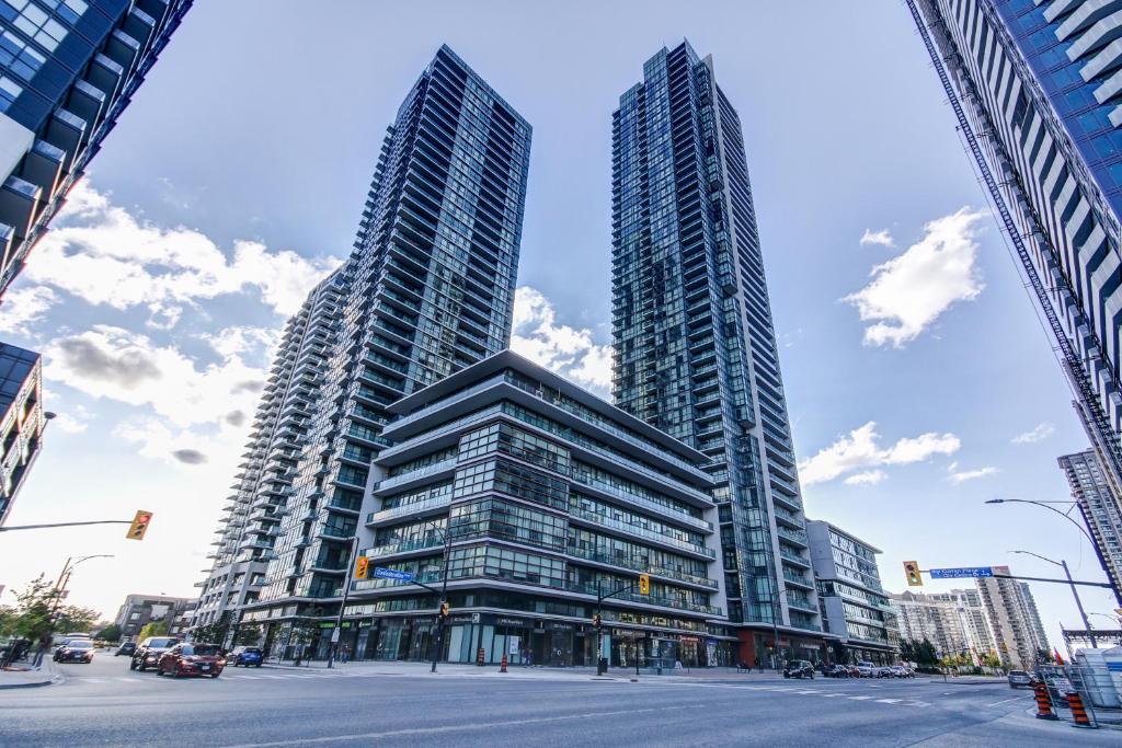 two tall buildings in a city with a street at The Benetton Suite - Square One 1 BR + Den + 1 Parking in Mississauga