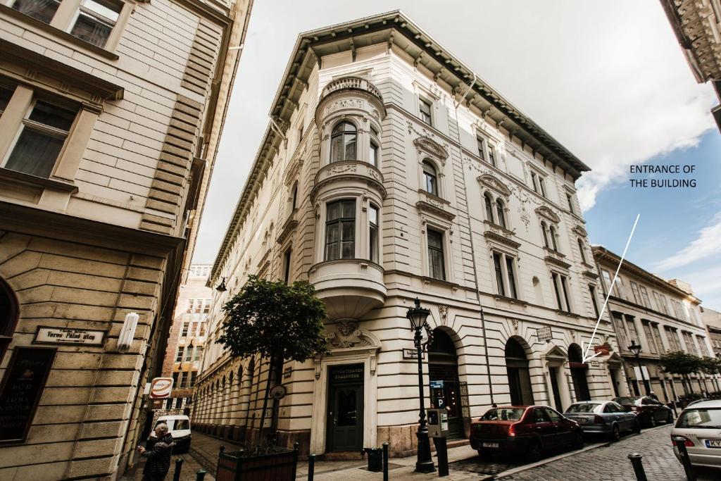 un edificio en una calle con coches aparcados delante en Romantic Hideaway Centertown, en Budapest