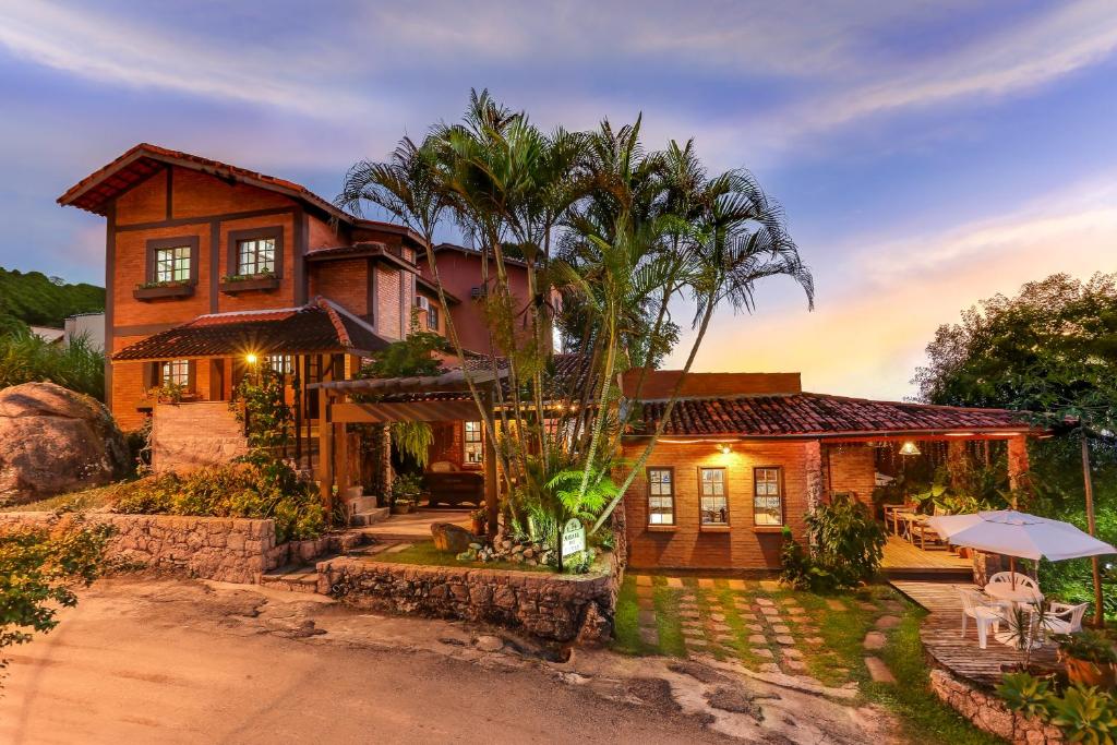 uma casa com uma palmeira em frente em Morada das Pedras em Florianópolis