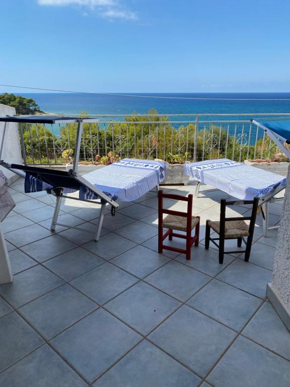 un patio con tavolo, sedie e vista sull'oceano di Casa Bella Vista a Morciano di Leuca