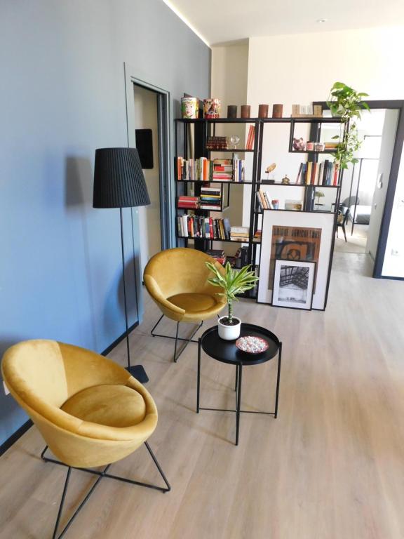 ein Wohnzimmer mit 2 Stühlen und einem Tisch in der Unterkunft Piumaviola Beds & Apartments in Parma