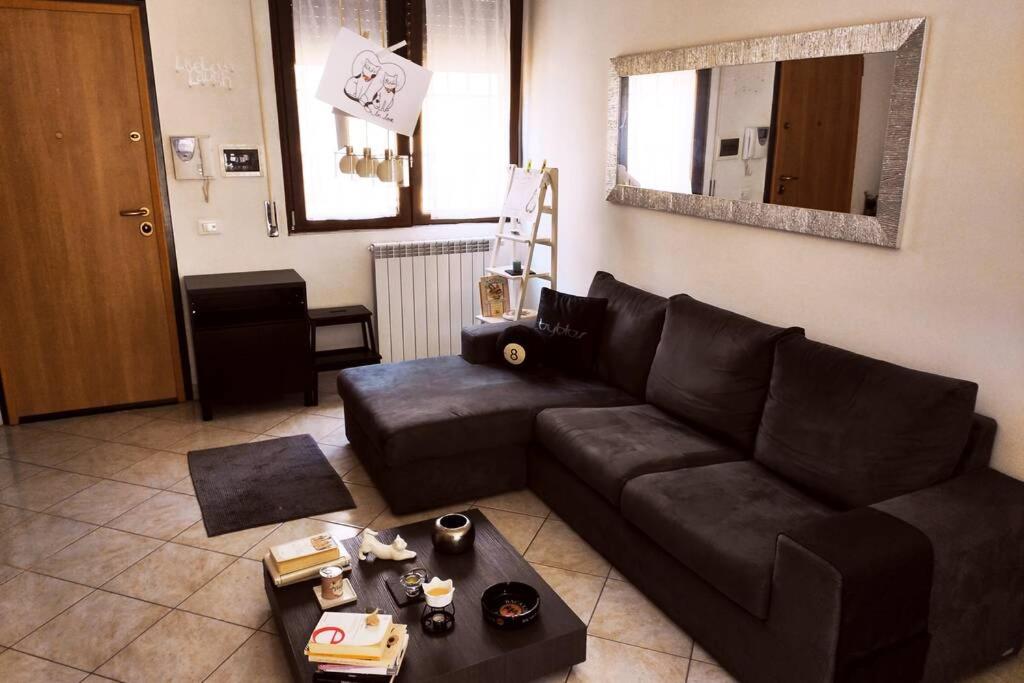 uma sala de estar com um sofá preto e uma mesa em Large house 3 floors City 'n sea em Vitinia