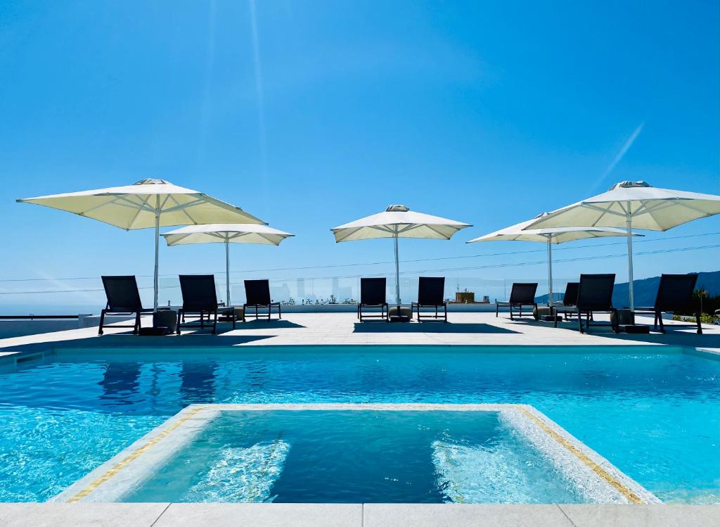 a swimming pool with chairs and umbrellas at Bungalow Los Laureles in El Paso