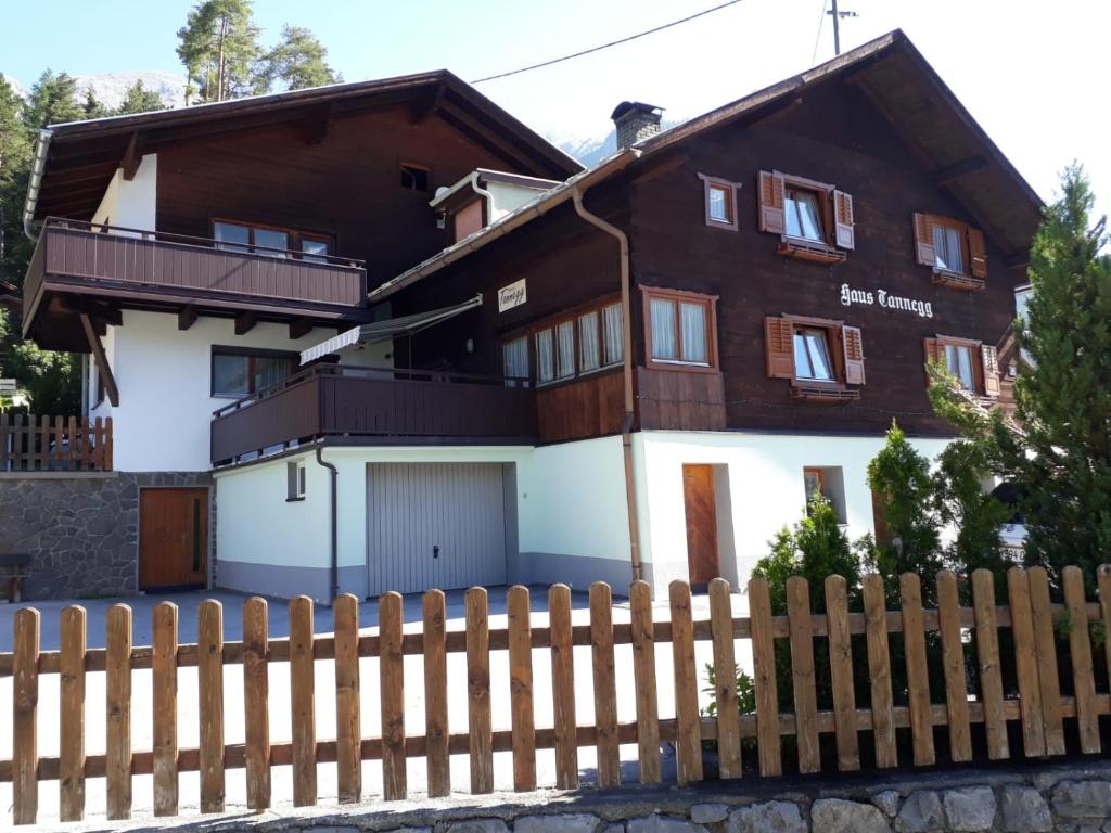 dom z drewnianym płotem przed nim w obiekcie Haus Tannegg w mieście Pettneu am Arlberg