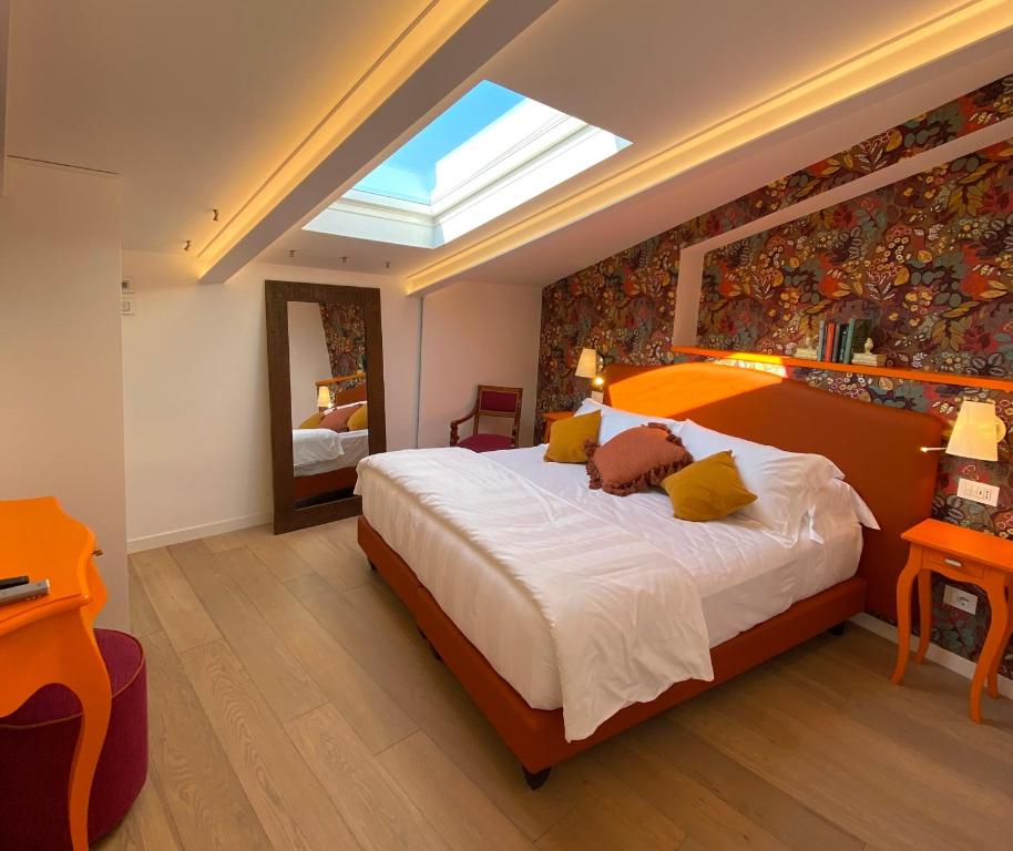 1 dormitorio con 1 cama grande y tragaluz en Grata Hospes Sorrento - Boutique House - Rooftop Deck - BBQ en Sorrento