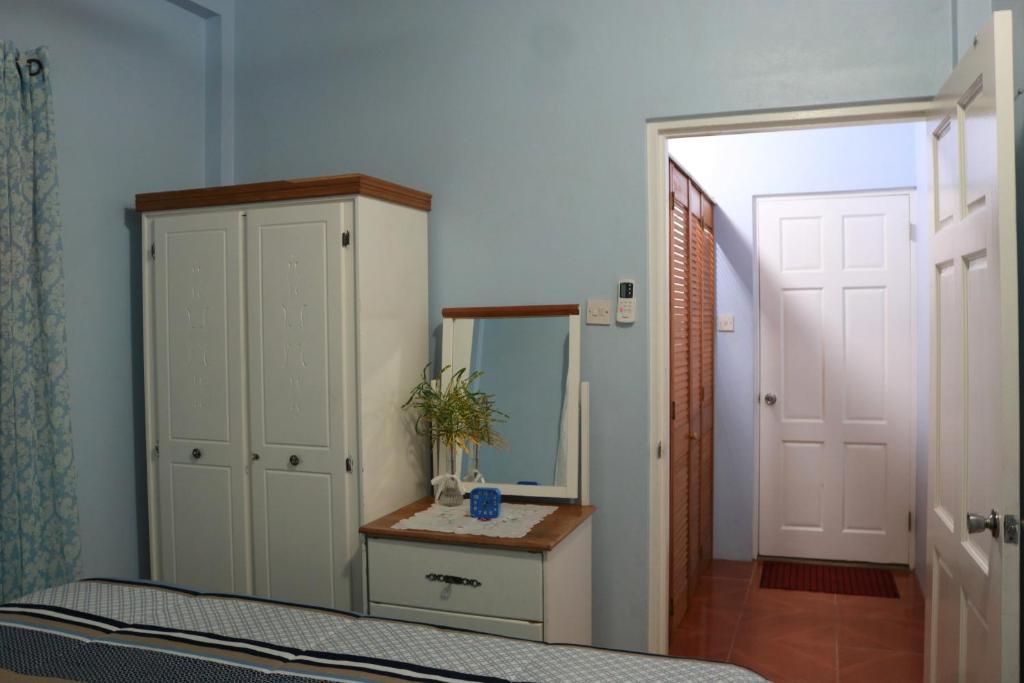a bedroom with a bed and a mirror and a door at Ocean Views and Hospitable Hosts in Castries