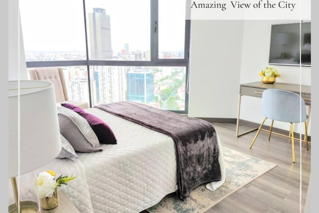 a bedroom with a bed and a desk and a window at Velasco MaiaHome-POLANCO Depa con alberca/gym/spa/jacuzzi + 3BR in Mexico City