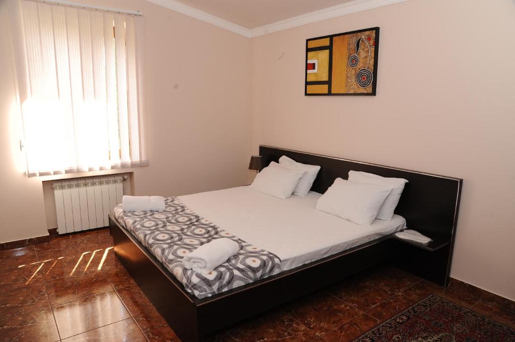 ein Schlafzimmer mit einem großen Bett mit weißer Bettwäsche und Kissen in der Unterkunft Villa 29 in Yerevan