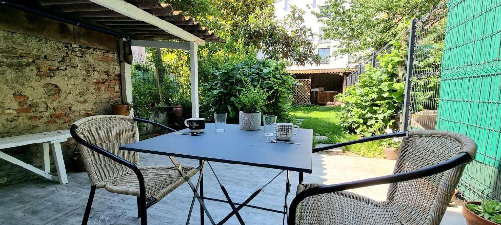une table bleue et deux chaises sur la terrasse dans l'établissement STUDIO SIMONE - TERRASSE ET JARDIN - TV - WIFI, à Toulouse
