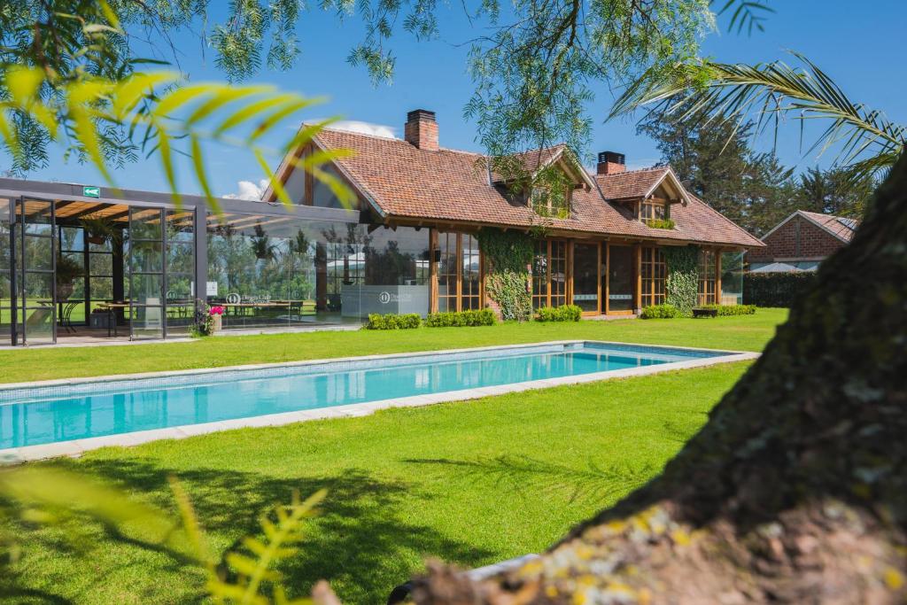 an exterior view of a house with a swimming pool at La Palma Polo Hotel - Airport Area in Puembo