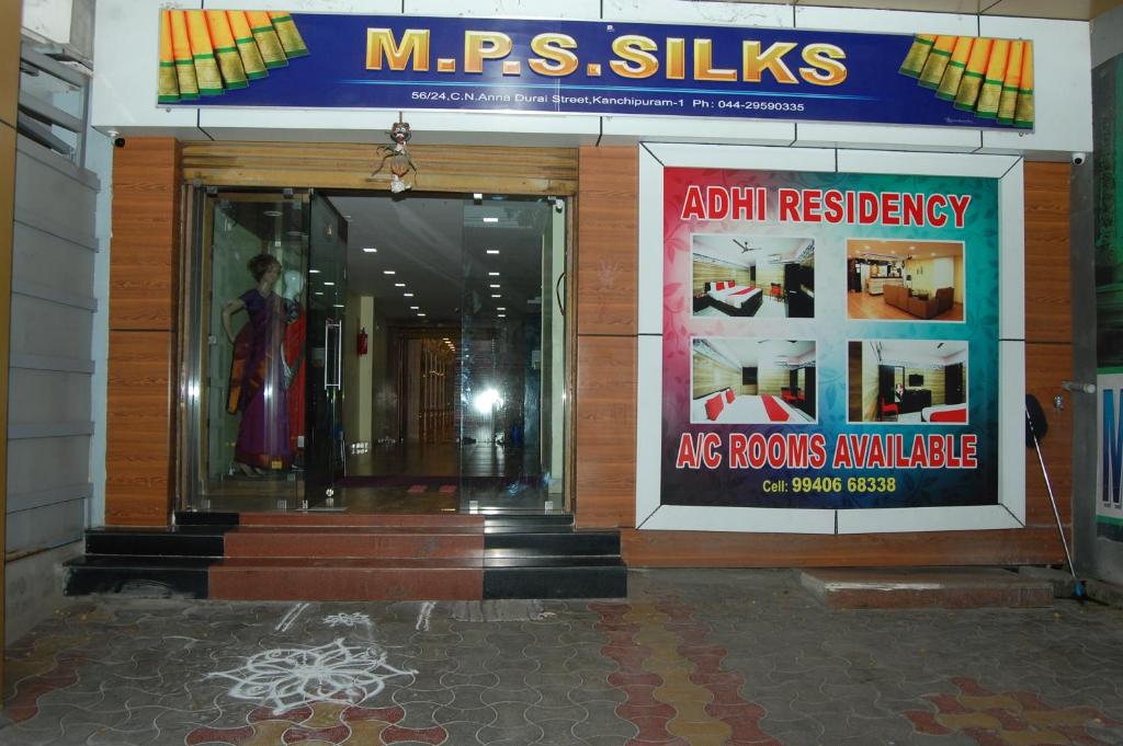 uma frente de loja com cartazes na frente em Adhi Residency em Kanchipuram