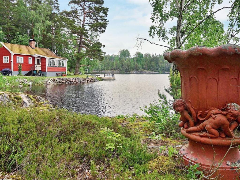 a statue of two children sitting on a fire hydrant by a lake at 5 person holiday home in KERSBERGA in Åkersberga