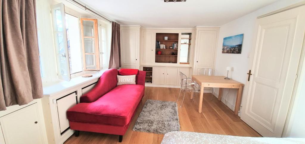uma sala de estar com uma cadeira vermelha e uma mesa em Boël 5 studio em Genebra
