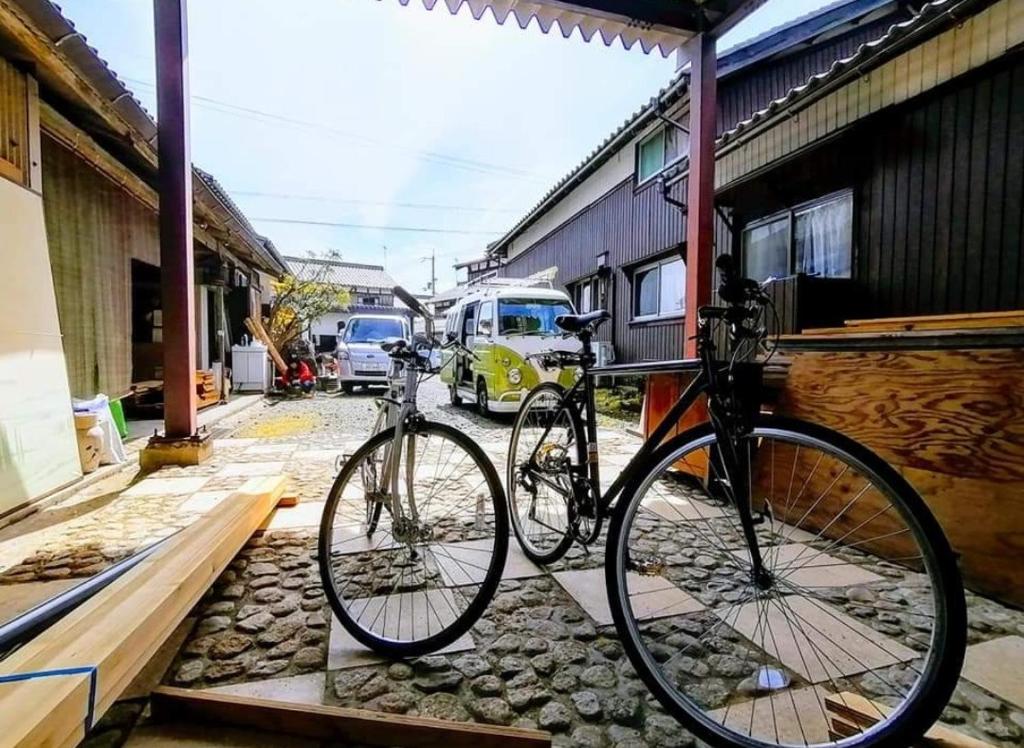 een paar fietsen geparkeerd naast een gebouw bij 静かに過ごす古民家ステイ Staying quietly in renovated house in Takashima