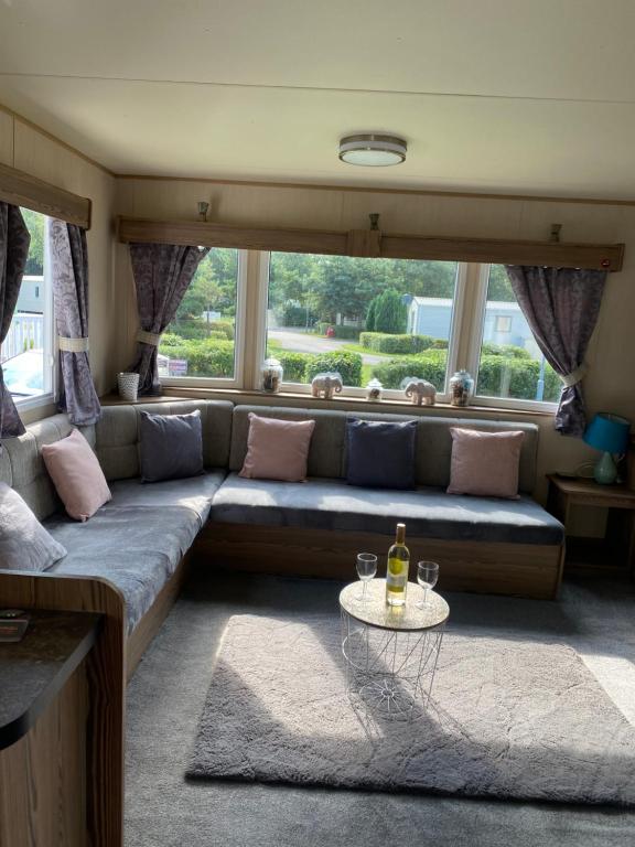 a living room with a couch and a table with a bottle of wine at Seton Sands Haven Holiday Village in Port Seton