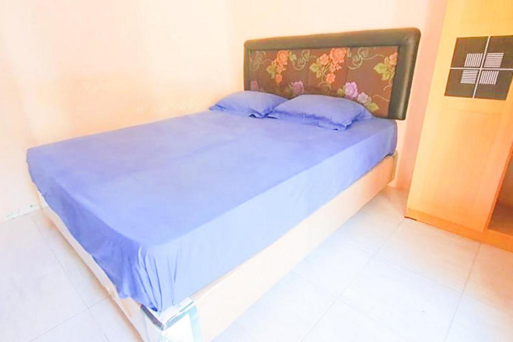 A bed or beds in a room at Green Kanca Syariah Guest House Mitra RedDoorz