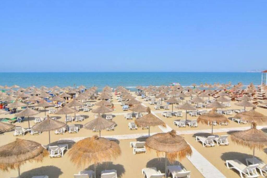 een strand met veel parasols en stoelen en de oceaan bij Fun in the Sun in Golem