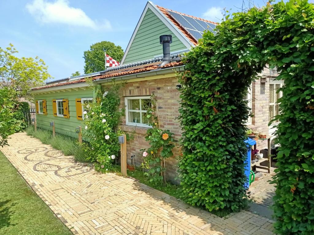 una casa di mattoni con un'edera che cresce intorno di De Ketse Steenuil a Kaatsheuvel