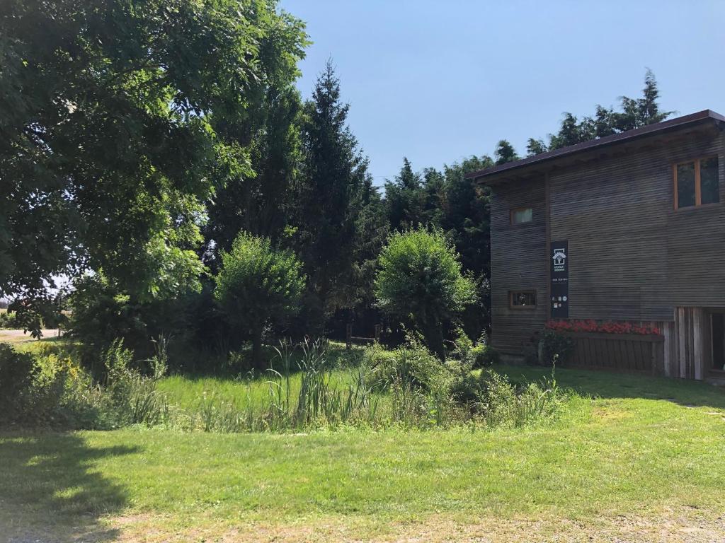 un edificio en un campo junto a un patio en Le Domaine Des Zoiseaux - LDDZ des Flandres, en Vieux-Berquin