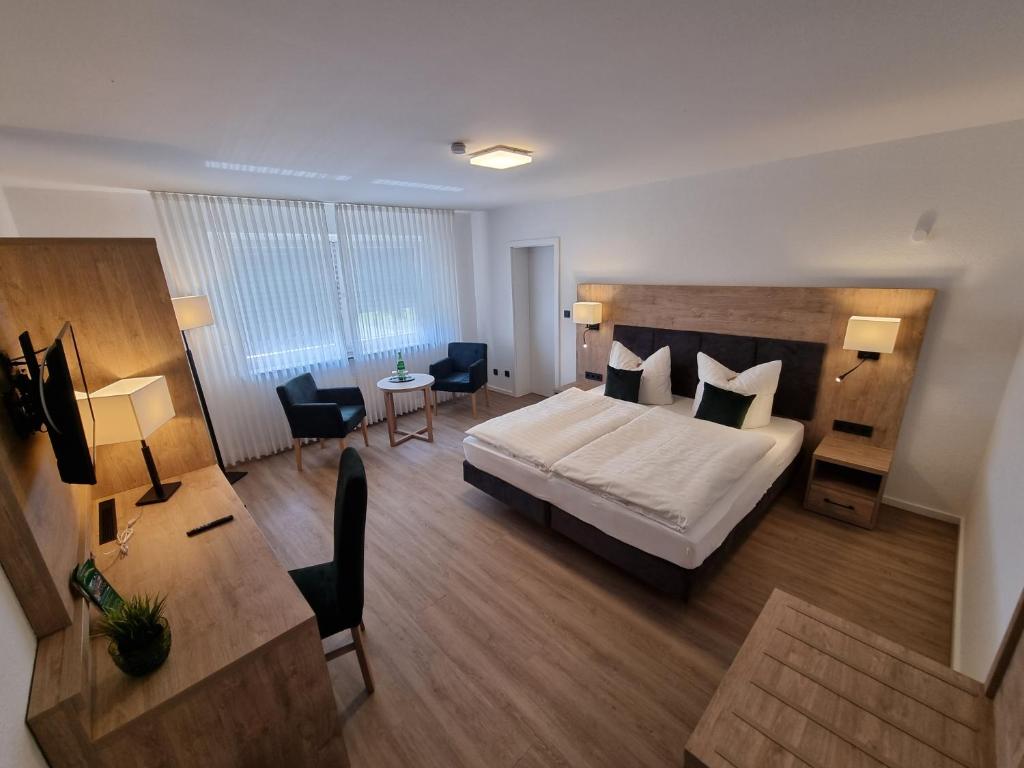 ヴレーデンにあるHotel Zum Jägerhausのベッド、テーブル、椅子が備わるホテルルームです。
