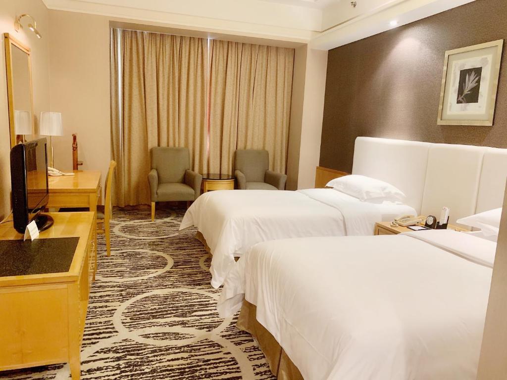 Postel nebo postele na pokoji v ubytování Guangzhou Baiyun Hotel