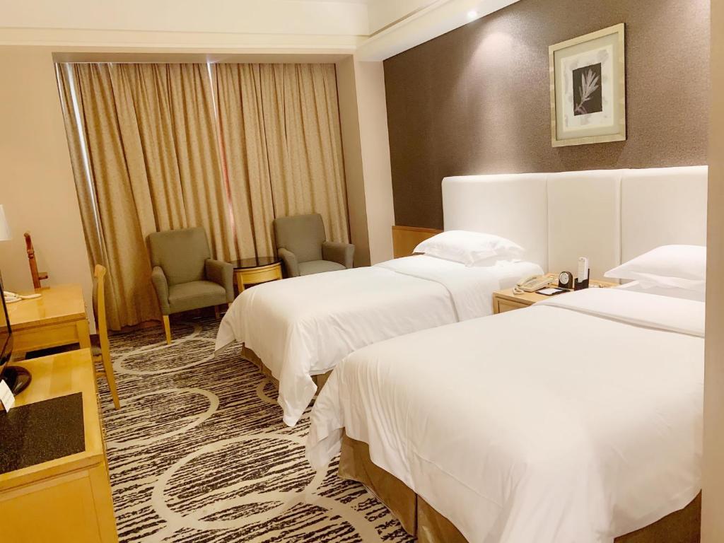 Postel nebo postele na pokoji v ubytování Guangzhou Baiyun Hotel