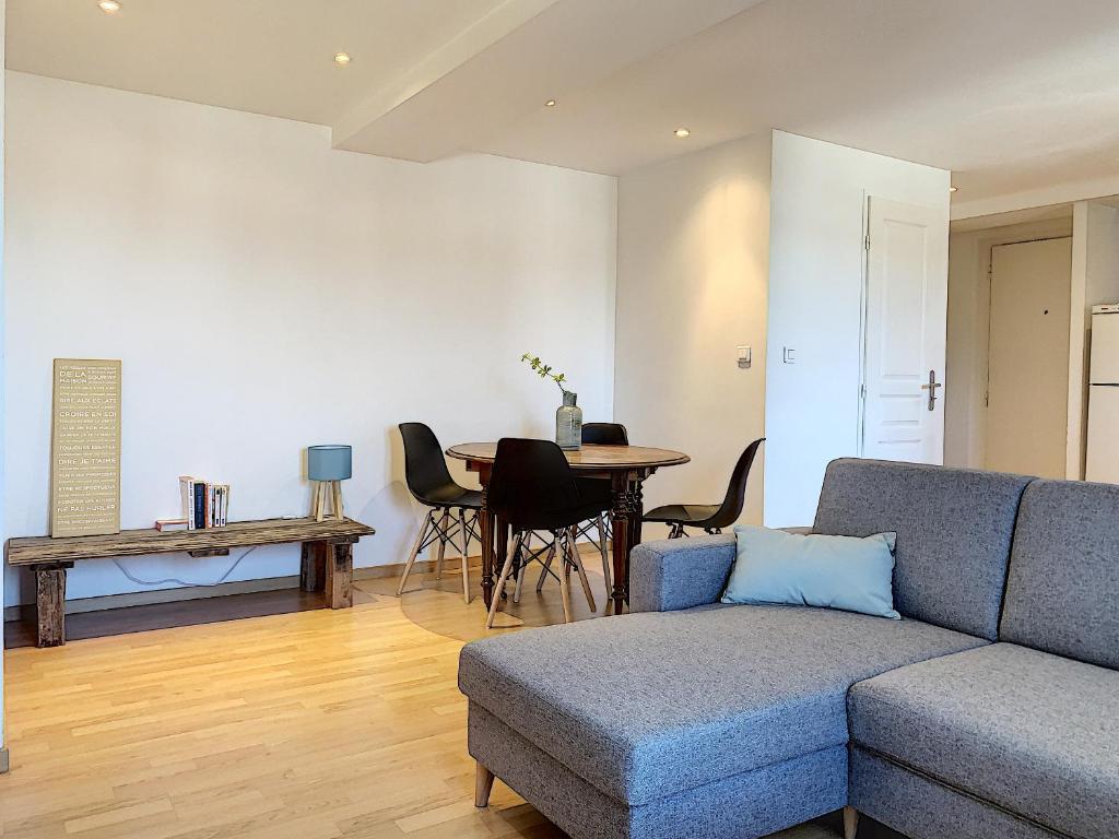 een woonkamer met een bank en een tafel bij Bourgoin-Jallieu Appartement les Augustins in Bourgoin