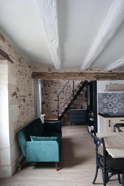 un soggiorno con divano verde e tavolo di LE BON’HEURE ad Abilly-Sur-Claise