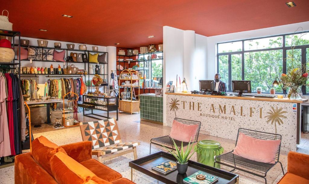 The Amalfi Boutique Hotel في كيب تاون: يوجد متجر به أريكة وكراسي في الغرفة