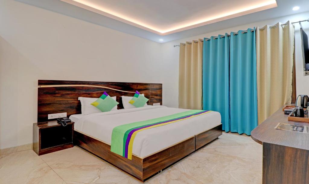 a bedroom with a bed and a desk and a television at Hotel Hidden Delight Rishikesh in Rishīkesh