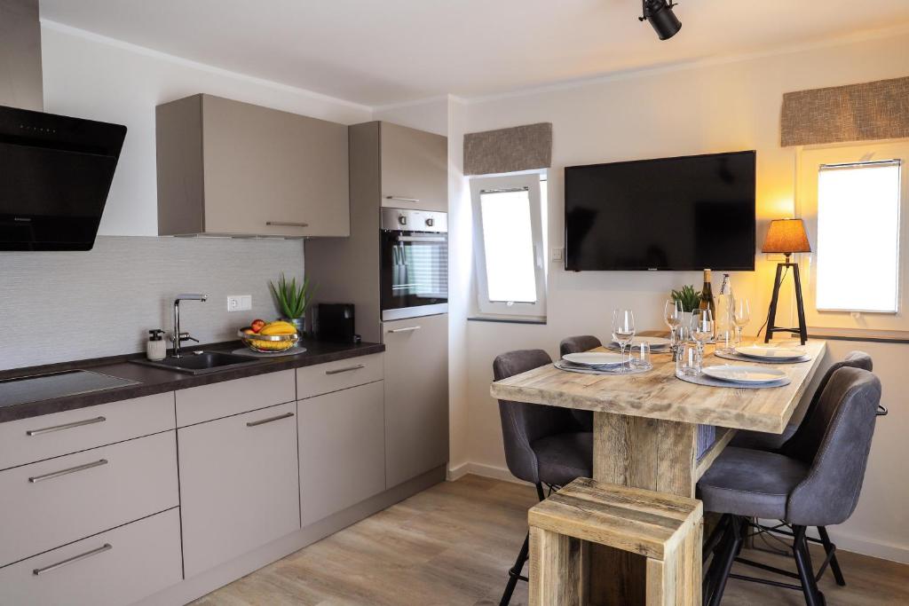 a kitchen with a table with chairs and a television at Smart Resorts Topas 301 in Winterberg