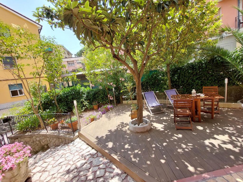 a wooden deck with a table and chairs under a tree at Albamare in Monterosso al Mare