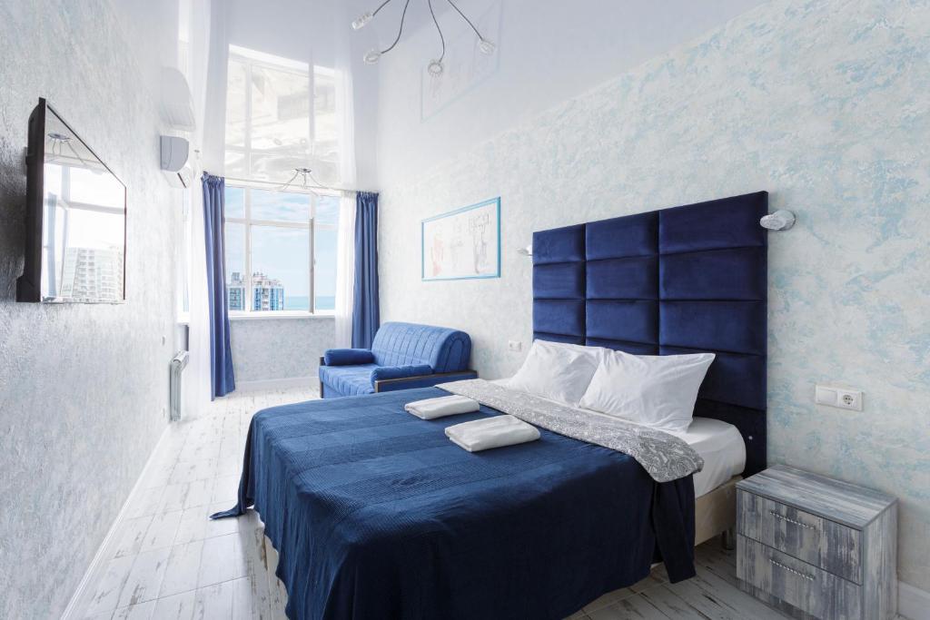 a bedroom with a blue bed and a blue chair at Мандарин in Sochi