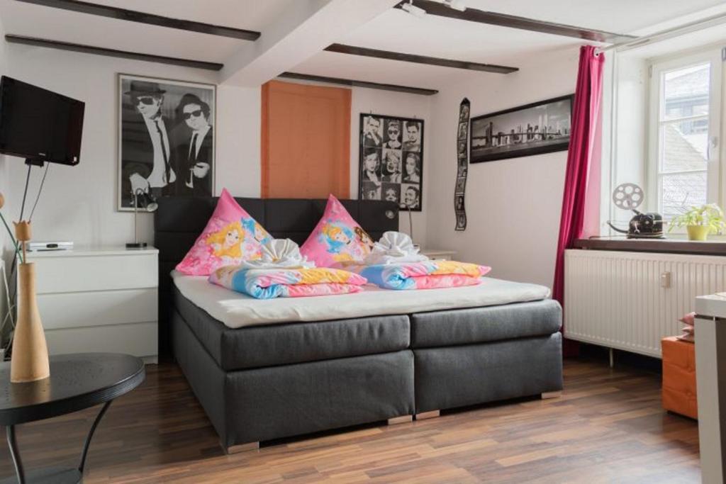 - un salon avec un canapé et des oreillers roses dans l'établissement Pension Harmony, à Marbourg