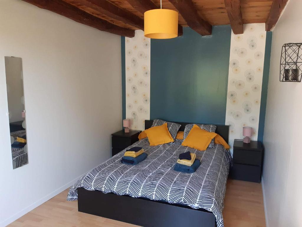 Chambre à Ineuil في Ineuil: غرفة نوم عليها سرير ومخدات صفراء