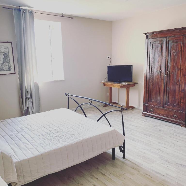 ein Schlafzimmer mit einem Bett und einem TV. in der Unterkunft LA CHIUSA Bed and Breakfast in Montichiari