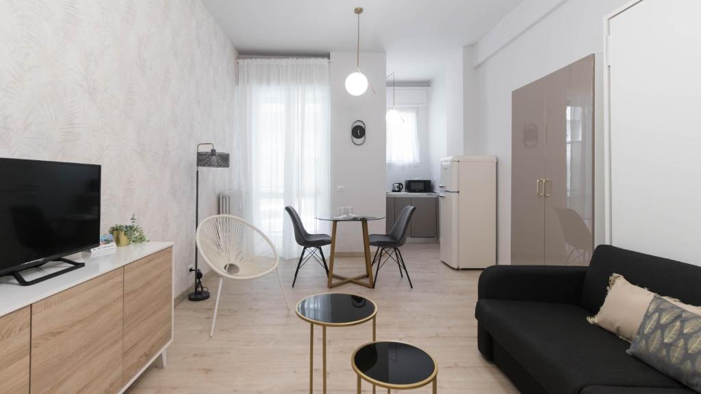 salon z czarną kanapą i stołem w obiekcie Italianway - Gioberti 11 w mieście Sesto San Giovanni