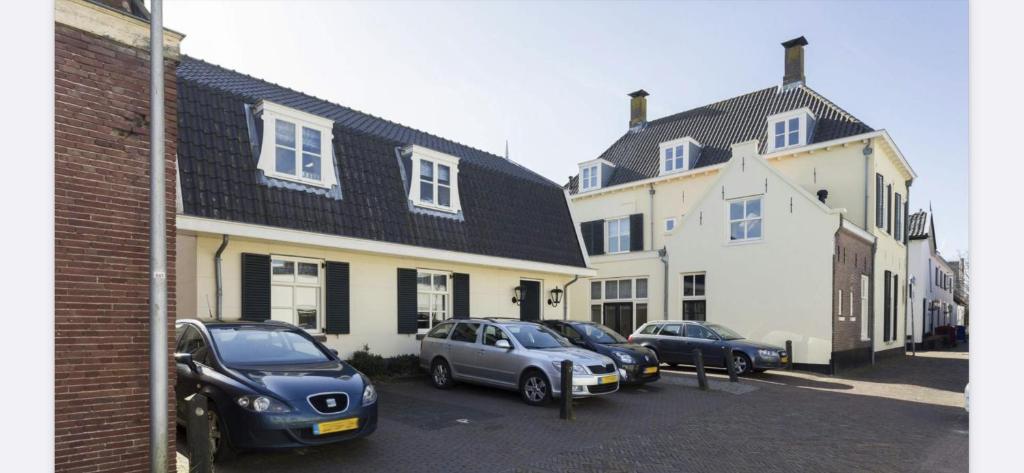 a group of cars parked in a parking lot next to buildings at Appartement Warmond in Warmond