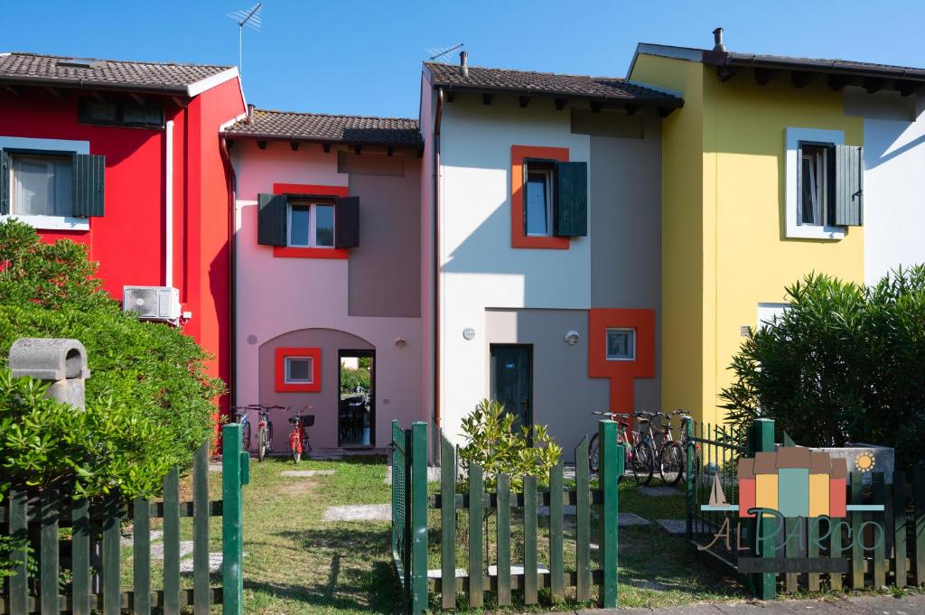 uma fila de casas coloridas atrás de uma cerca em Fiordo Mare Vostrum em Ilha Albarella