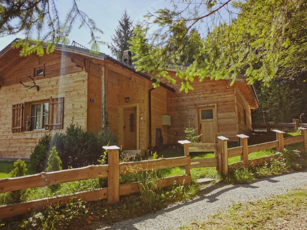 une cabane en rondins avec une clôture devant elle dans l'établissement Stodingerhütte, à Winkl