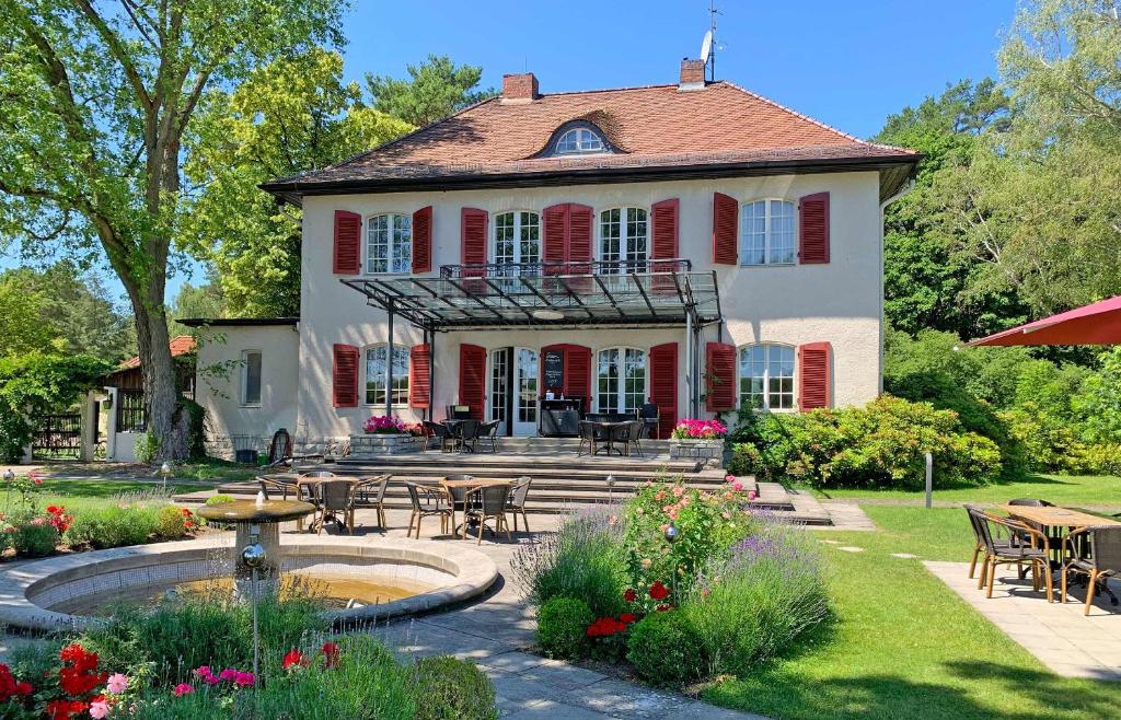 une grande maison avec une fontaine dans la cour dans l'établissement Hotel Waldhaus Prieros, à Prieros