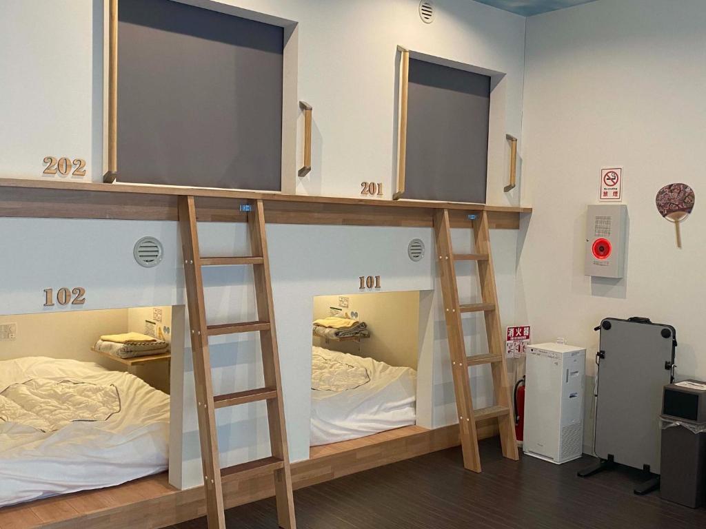 弘前的住宿－HOSTEL HIROSAKI -Mixed dormitory-Vacation STAY 32012v，带2张床的客房中的2张双层床
