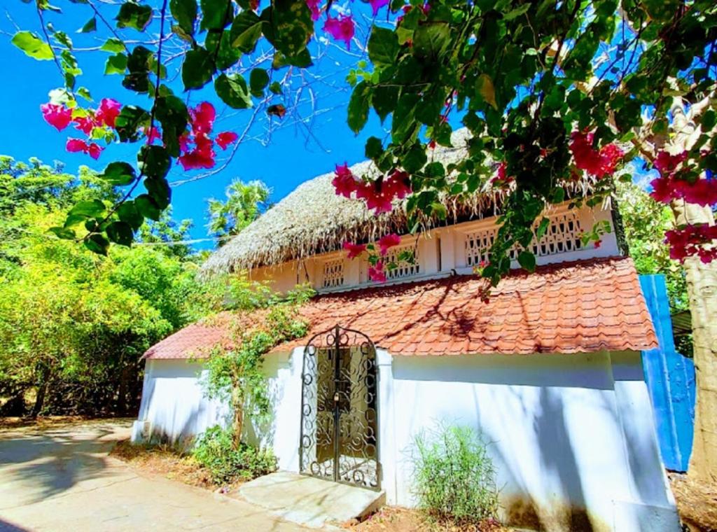 an old house with a thatched roof and a gate at Angel Heritage Home - Serenity Beach, Pondicherry. in Puducherry