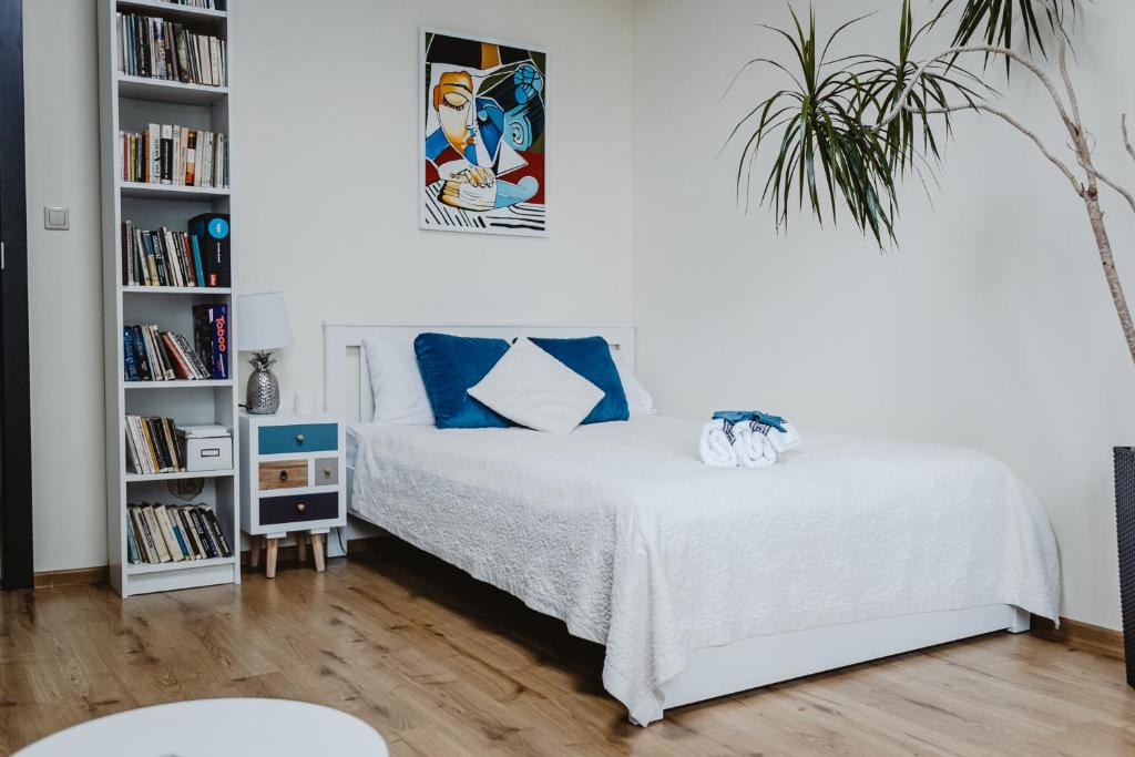 um quarto com uma cama e uma estante de livros em Apartament Blue em Lublin