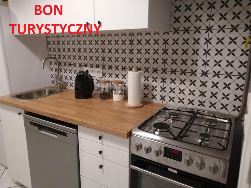 a kitchen counter with a stove and a sink at Pokoje w Centrum Sopotu in Sopot