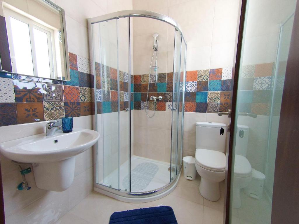 a bathroom with a shower and a sink and a toilet at F11 Modern and Bright Apartment in Malta in Msida